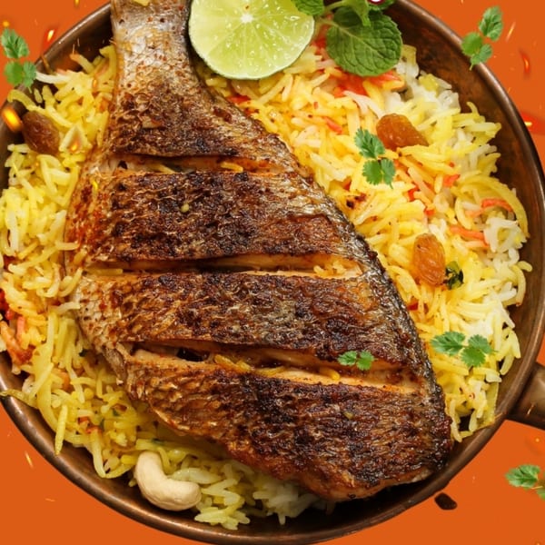 Grilled whole fish on a bed of yellow biryani rice with lime, mint, cashews, and raisins.
